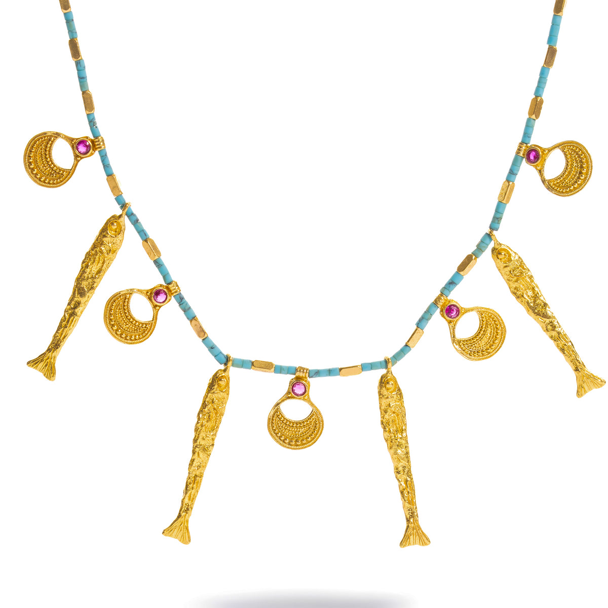Close view of the turquoise beaded strand showing the gold spacers and the ruby zircon set into each granulated crescent