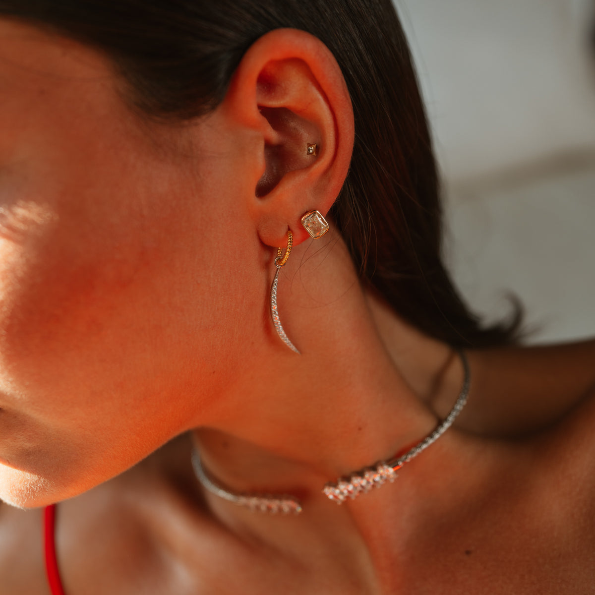 Luminous Arc earring worn with a square stud and the silver marquise zircon choker