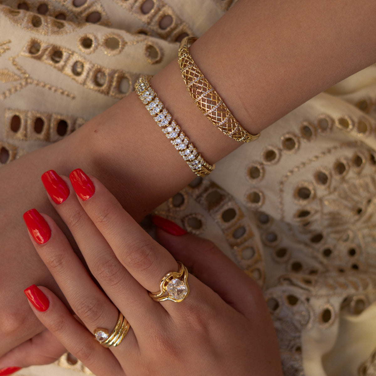 Crossed wrists wearing the Luminous Halo zircon tennis bracelet with a gold lattice cuff and gold rings