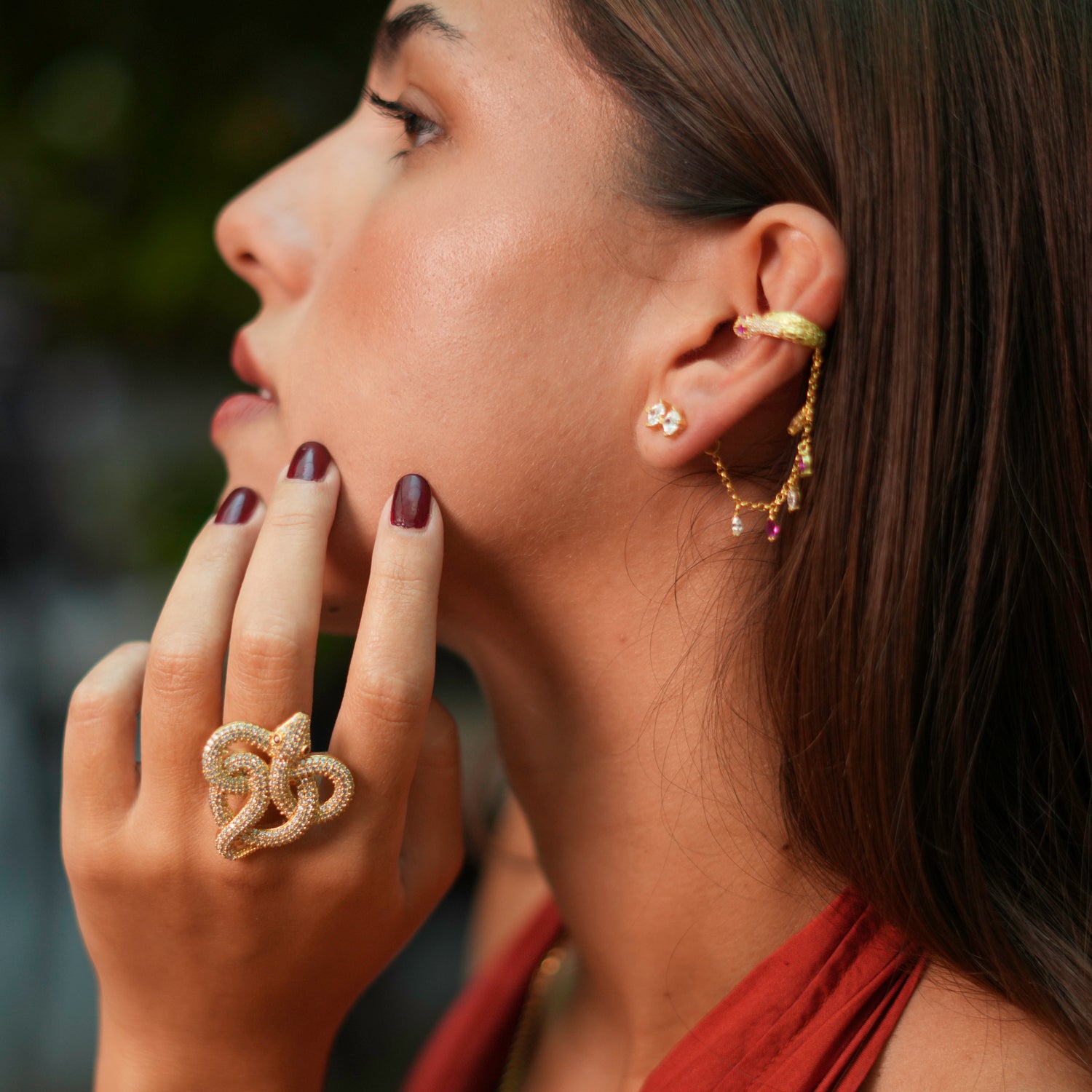 24k gold-plated chunky ring featuring a snake adorned with sparkling CZ diamonds and green eyes, adjustable for a perfect fit.
