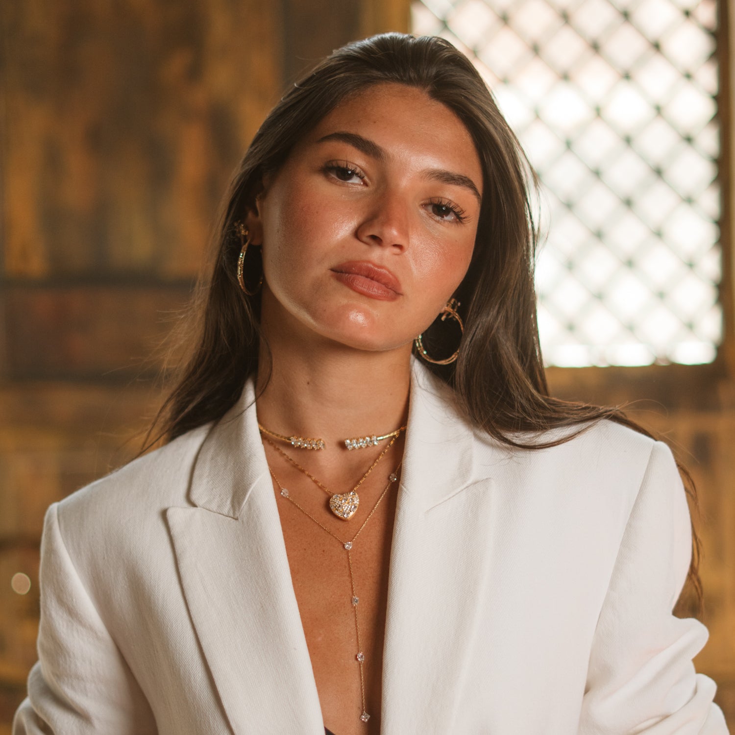 Woman in a white blazer wearing a gold vermeil marquise choker layered with fine gold chains