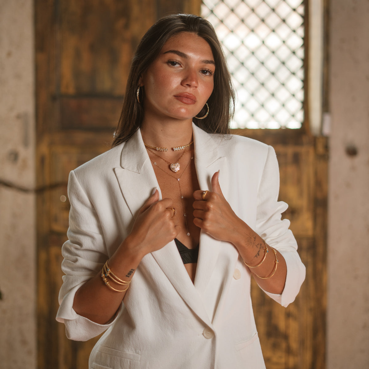 Model in a white suit wearing a hand woven gold vermeil choker necklace