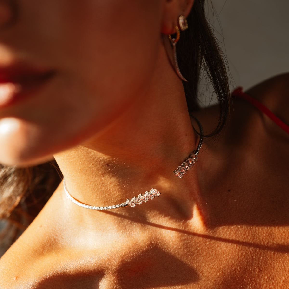 Close up of a woven sterling silver choker with graduated marquise cubic zirconia at the collarbone
