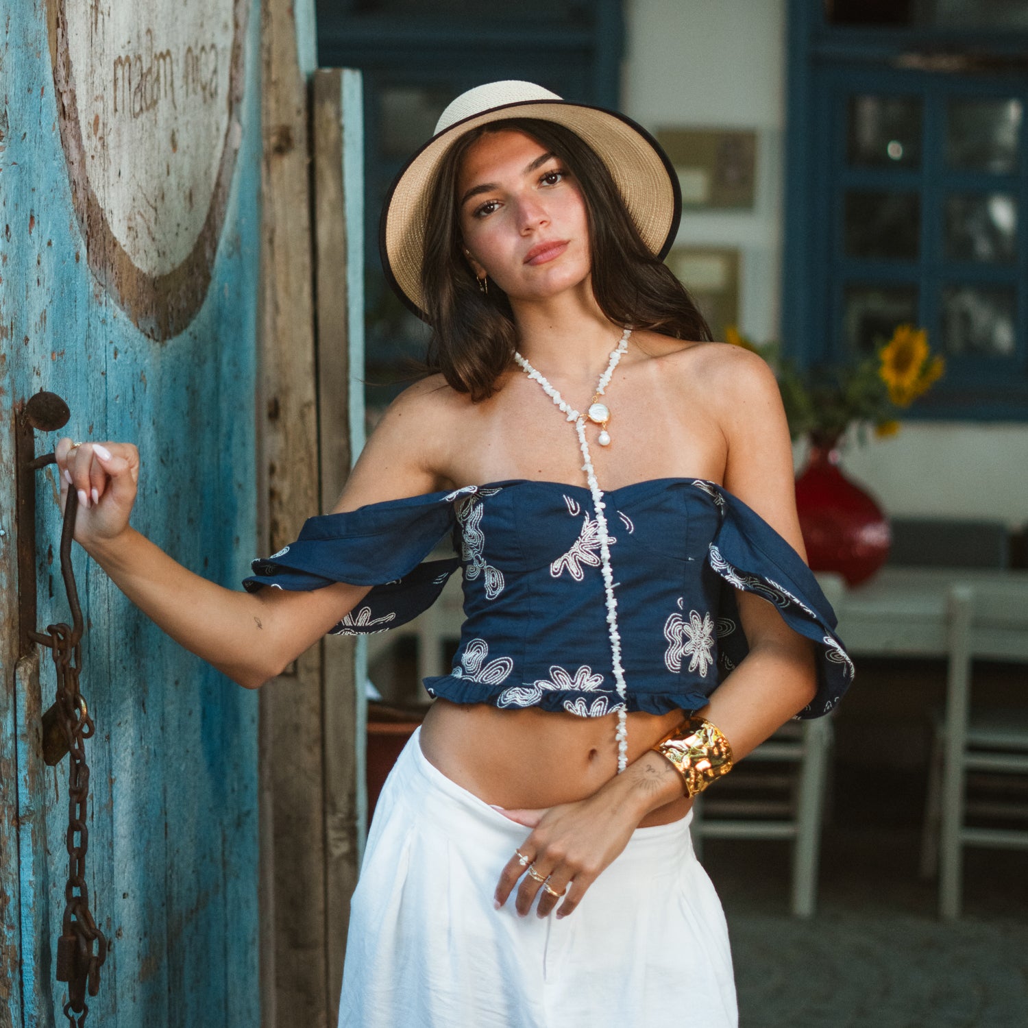 Model wearing the handmade moonstone quartz pearl lariat necklace layered over a boho off-shoulder top, styled with a straw hat