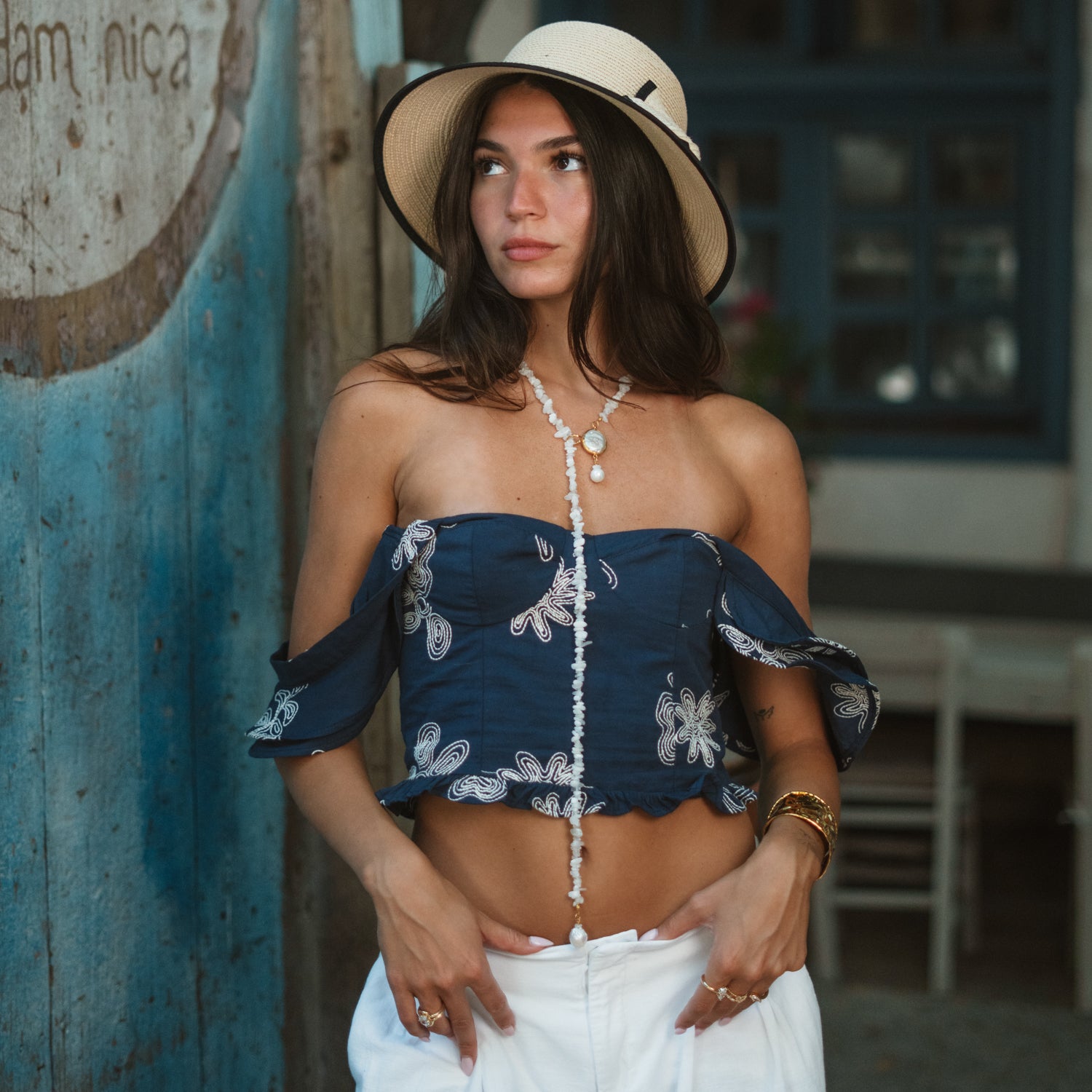 Model wearing the adjustable moonstone quartz beaded necklace with a baroque pearl slide, paired with a straw hat and boho outfit