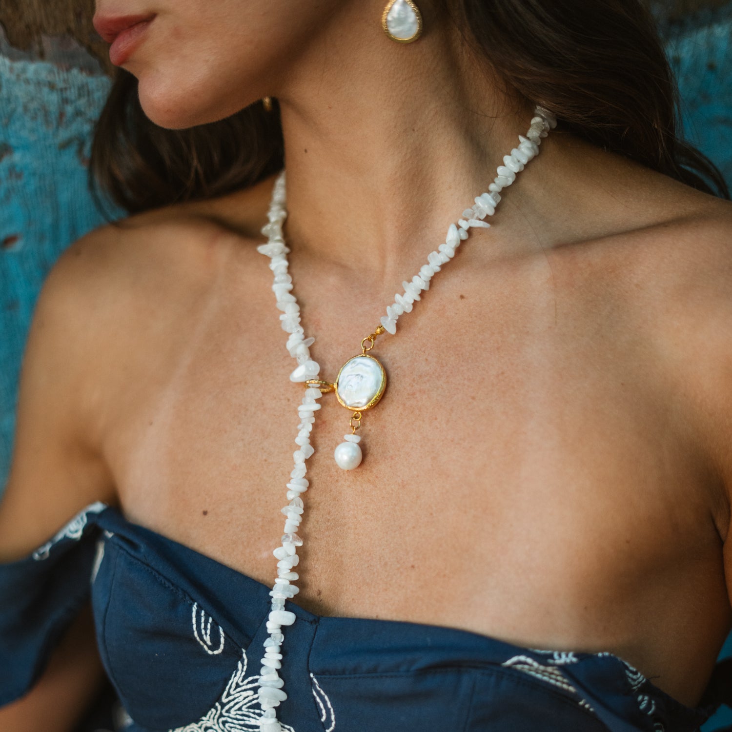 Close-up of the moonstone quartz lariat necklace worn at the collarbone, showing the gold plated baroque pearl slide and pearl drop detail