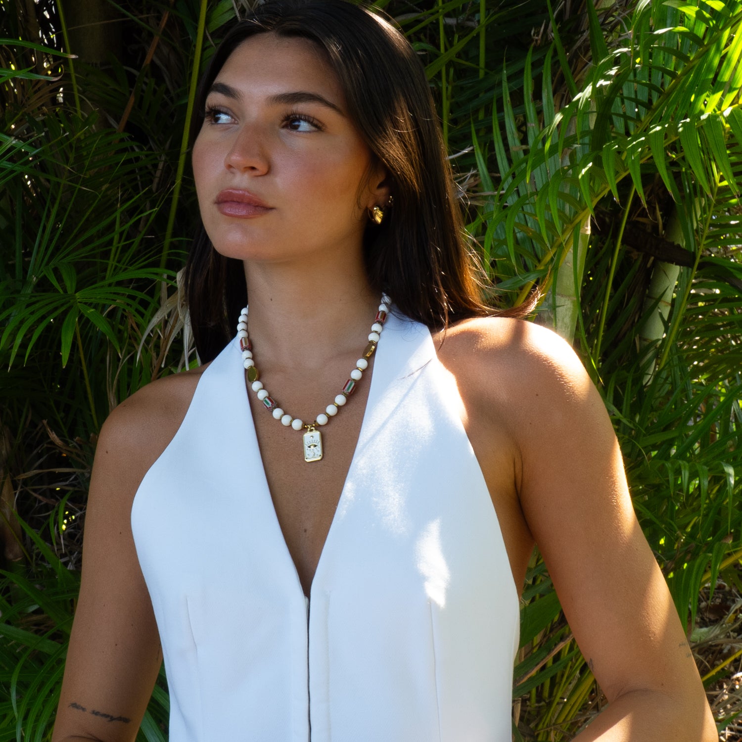 Woman wearing mystic eye tarot white jade talisman choker with white halter top
