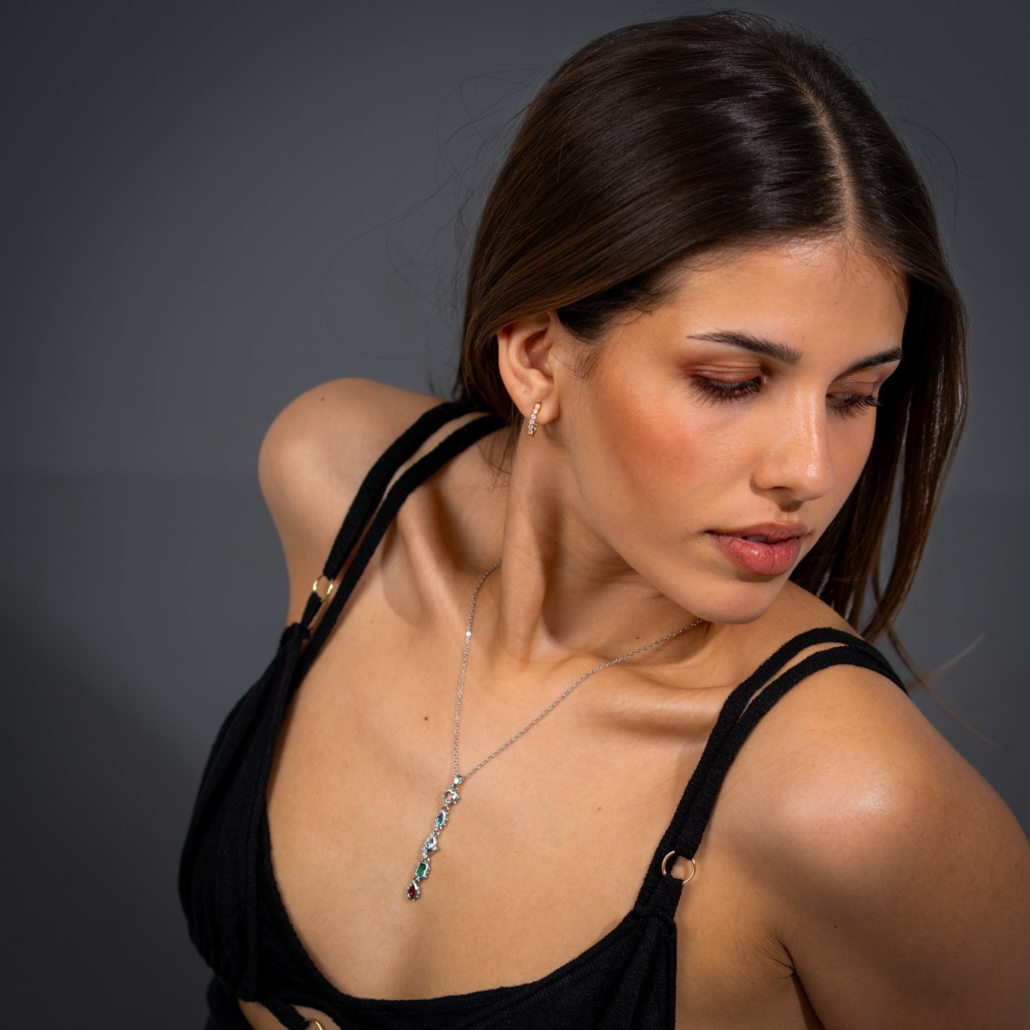 Mystic Guardian silver Y-drop necklace with heart and evil eye charms adorned with multicolor gemstones on a delicate stainless steel chain.

