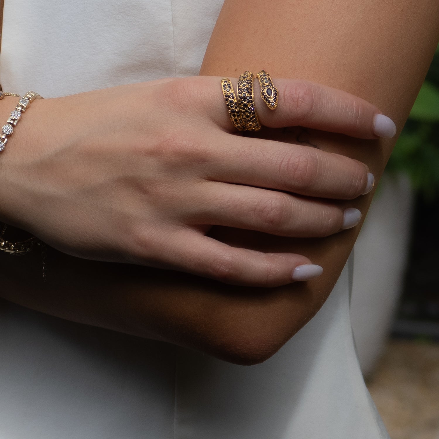 Modern Mystic Serpent Ring featuring a triple wrap design with black onyx accents and 18K gold plating.
