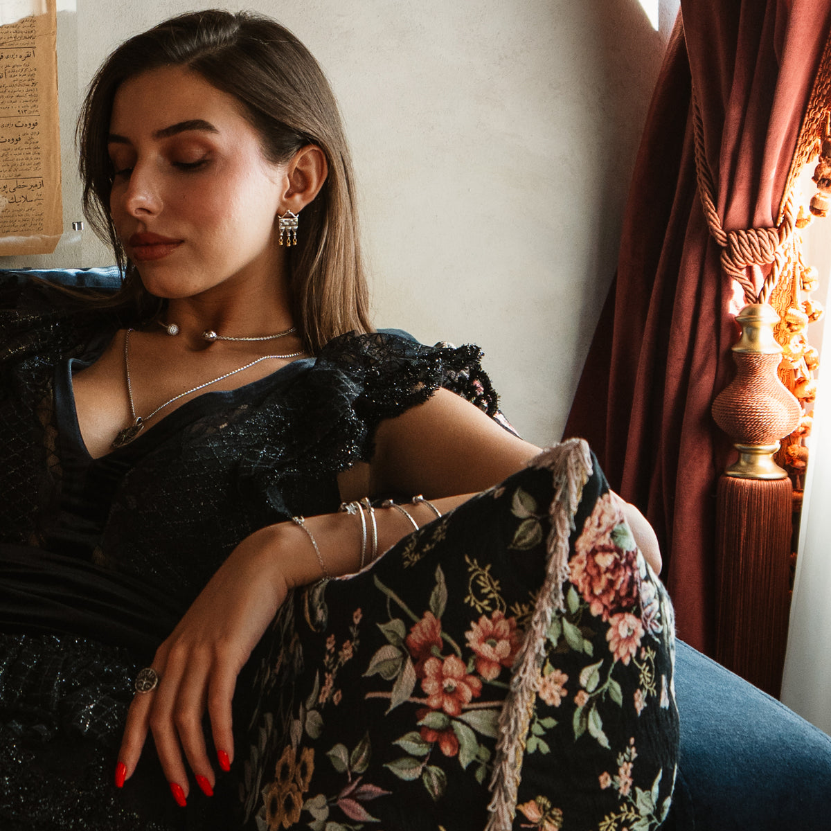 Model in a black lace dress wearing the Mystic Temple two tone silver earrings with silver necklaces