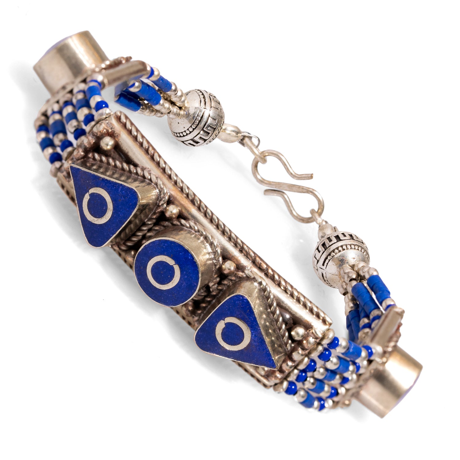 Chunky silver bracelet with intricate Nepalese patterns and striking lapis lazuli accents for a bohemian look.
