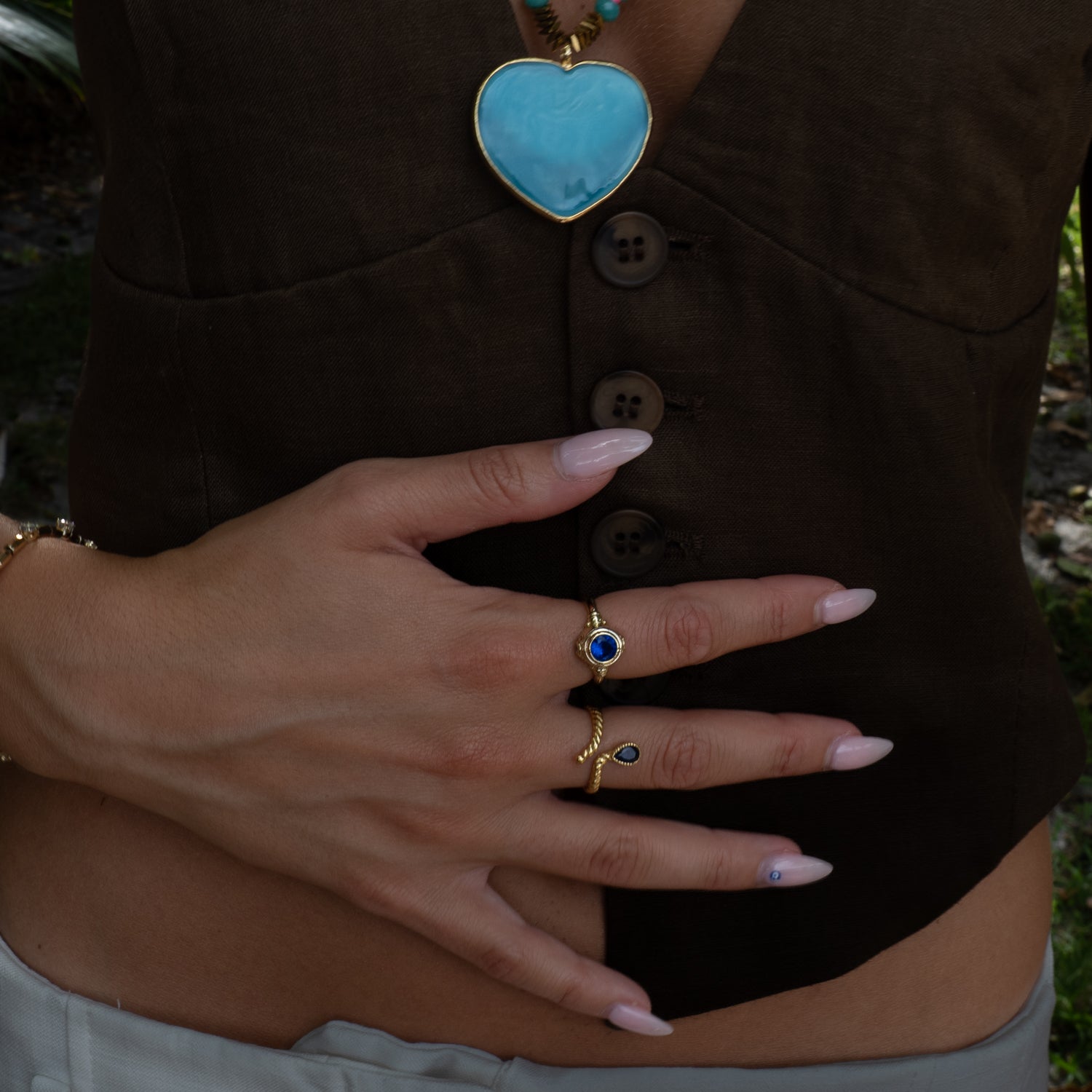 Hand with rings on a brown shirt background
