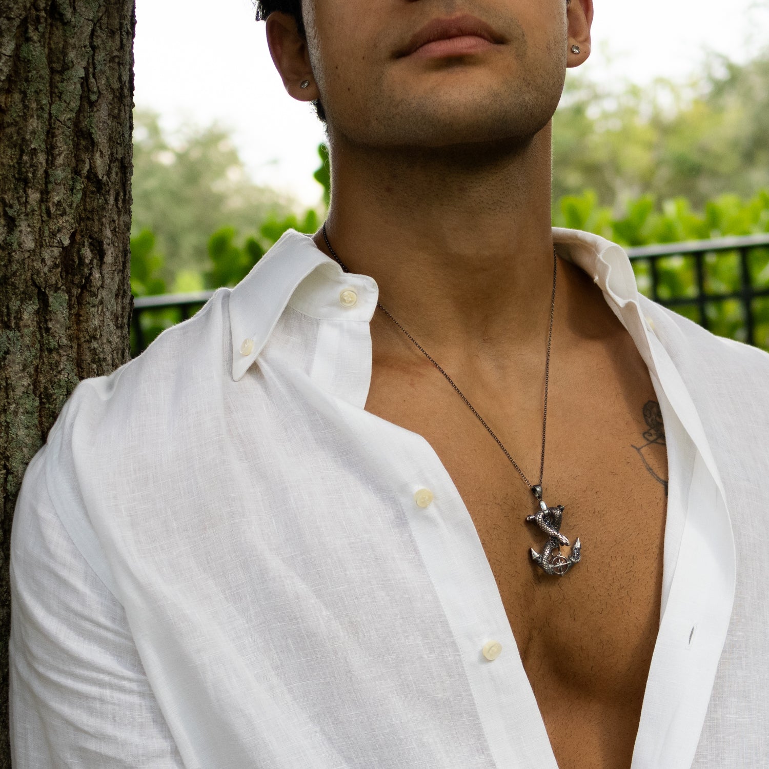 Sterling silver necklace with anchor pendant wrapped by serpent, compass detail, dark rhodium finish, masculine nautical style.