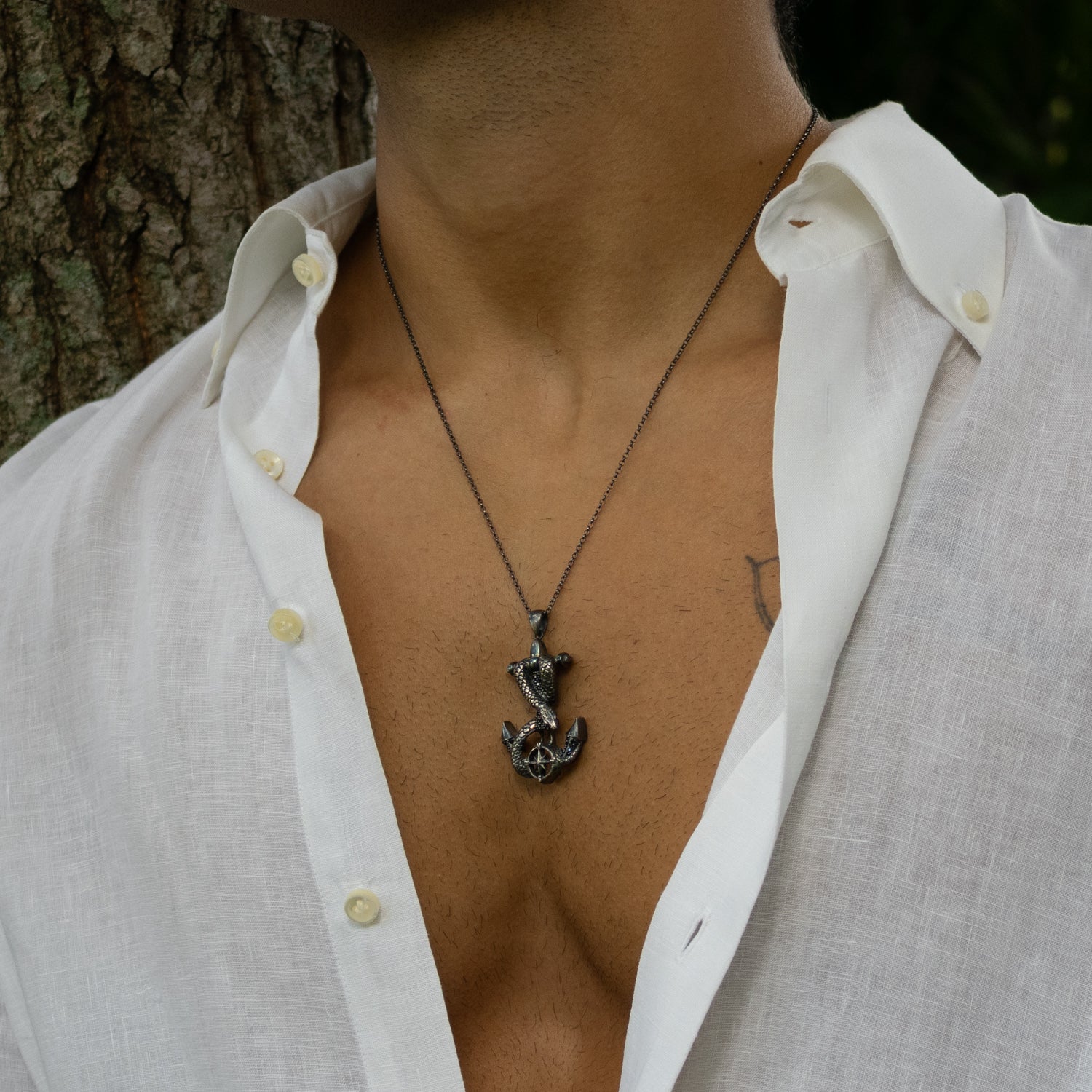 Sterling silver necklace with anchor pendant wrapped by serpent, compass motif, dark rhodium finish, masculine nautical style.