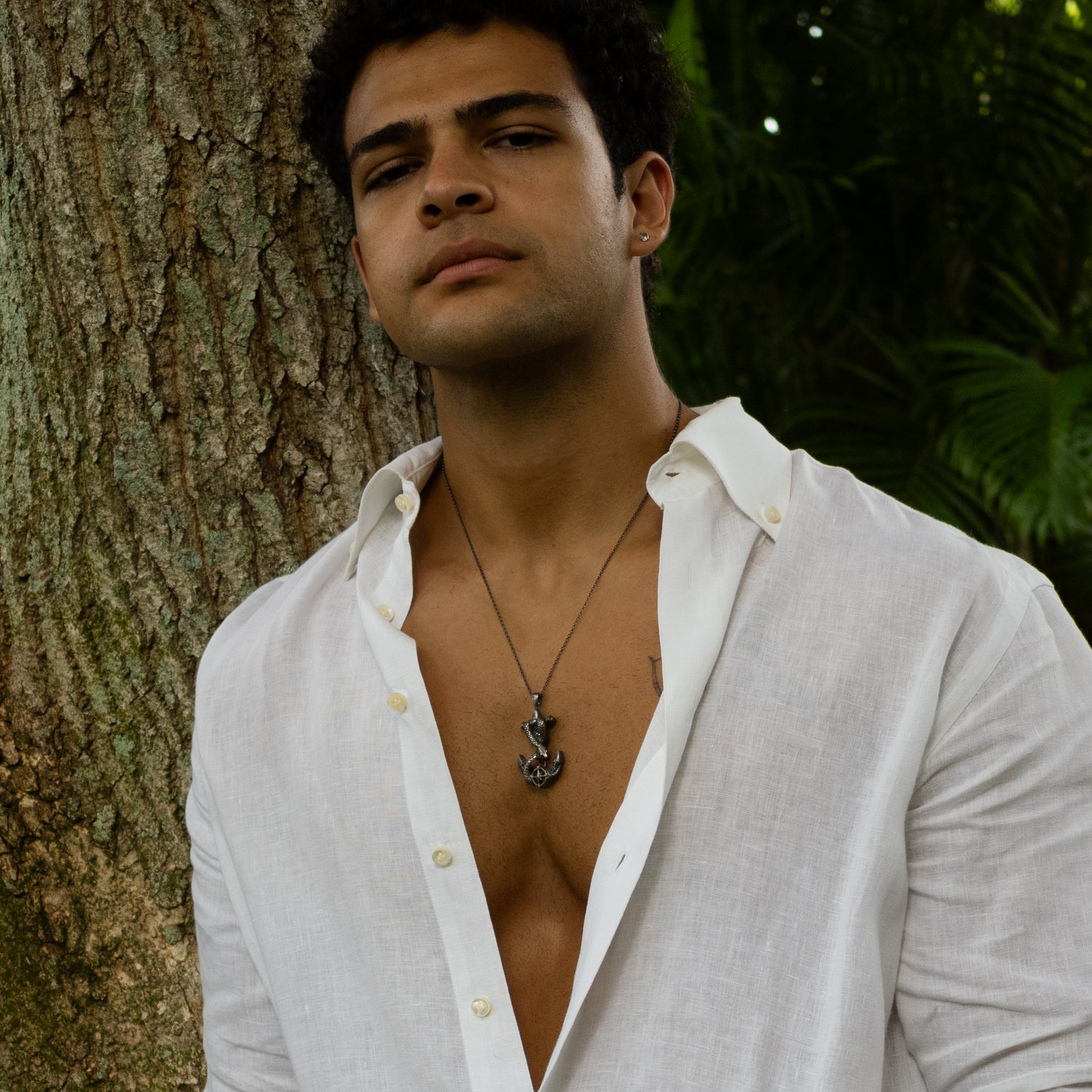 Sterling silver necklace with anchor pendant wrapped by serpent, compass detail, dark rhodium finish, masculine nautical style.