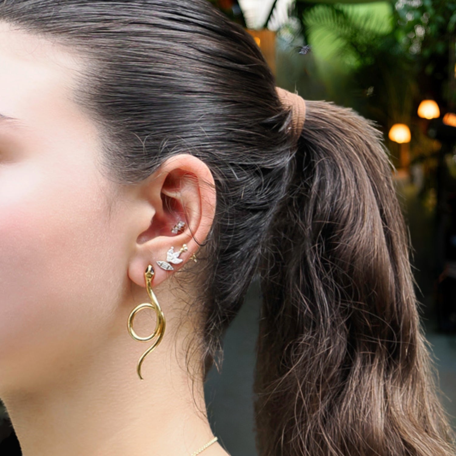 Chic serpent earrings with bold onyx eyes and sleek gold plating, designed for transformation and elegance.
