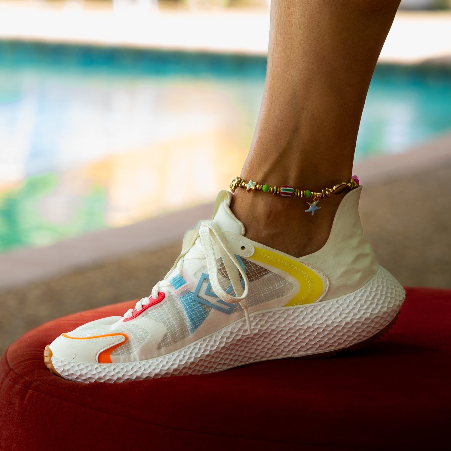 Woman wearing Pastel Colors Dream Star &amp; Fish Tail Beaded Anklet by turquoise water — dream aesthetic beach jewelry