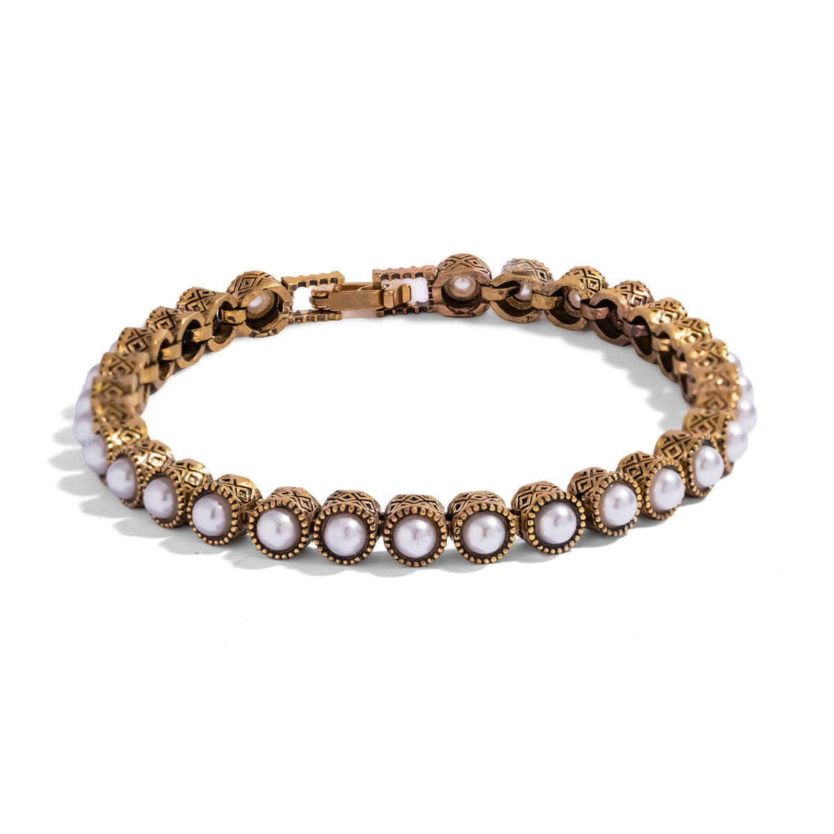 Antique gold pearl tennis bracelet shown in full, each pearl seated in its own patterned bezel