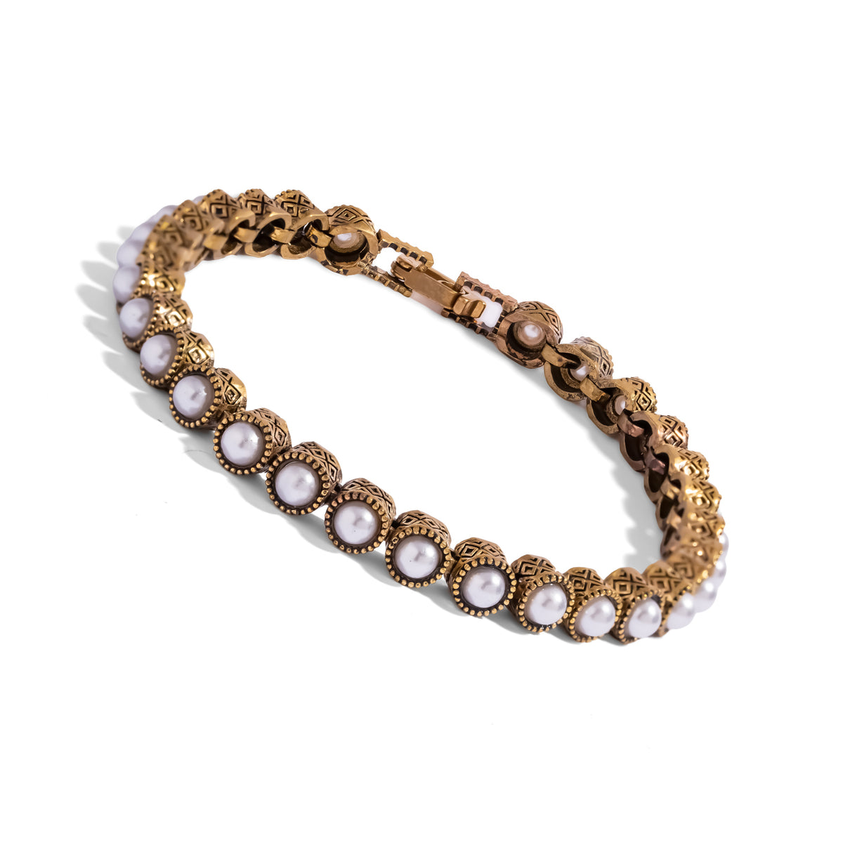 Angled studio view of the pearl tennis bracelet showing the fold over clasp and beaded bezel rims