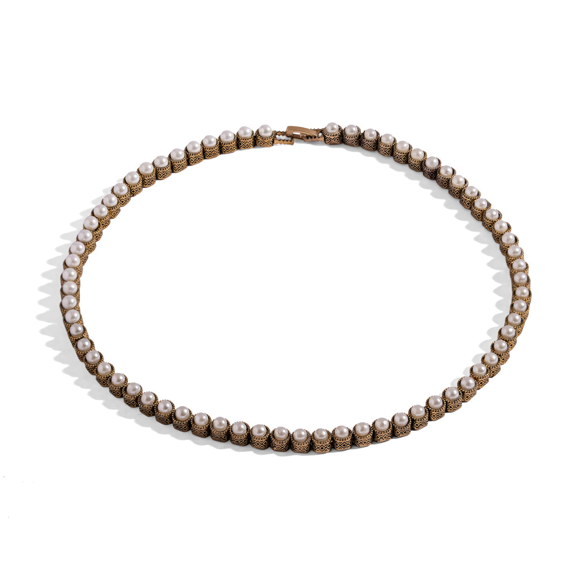 Pearl Antique Gold Tennis Mystic Necklace laid flat, an unbroken line of pearls in antiqued gold bezels with a concealed box clasp