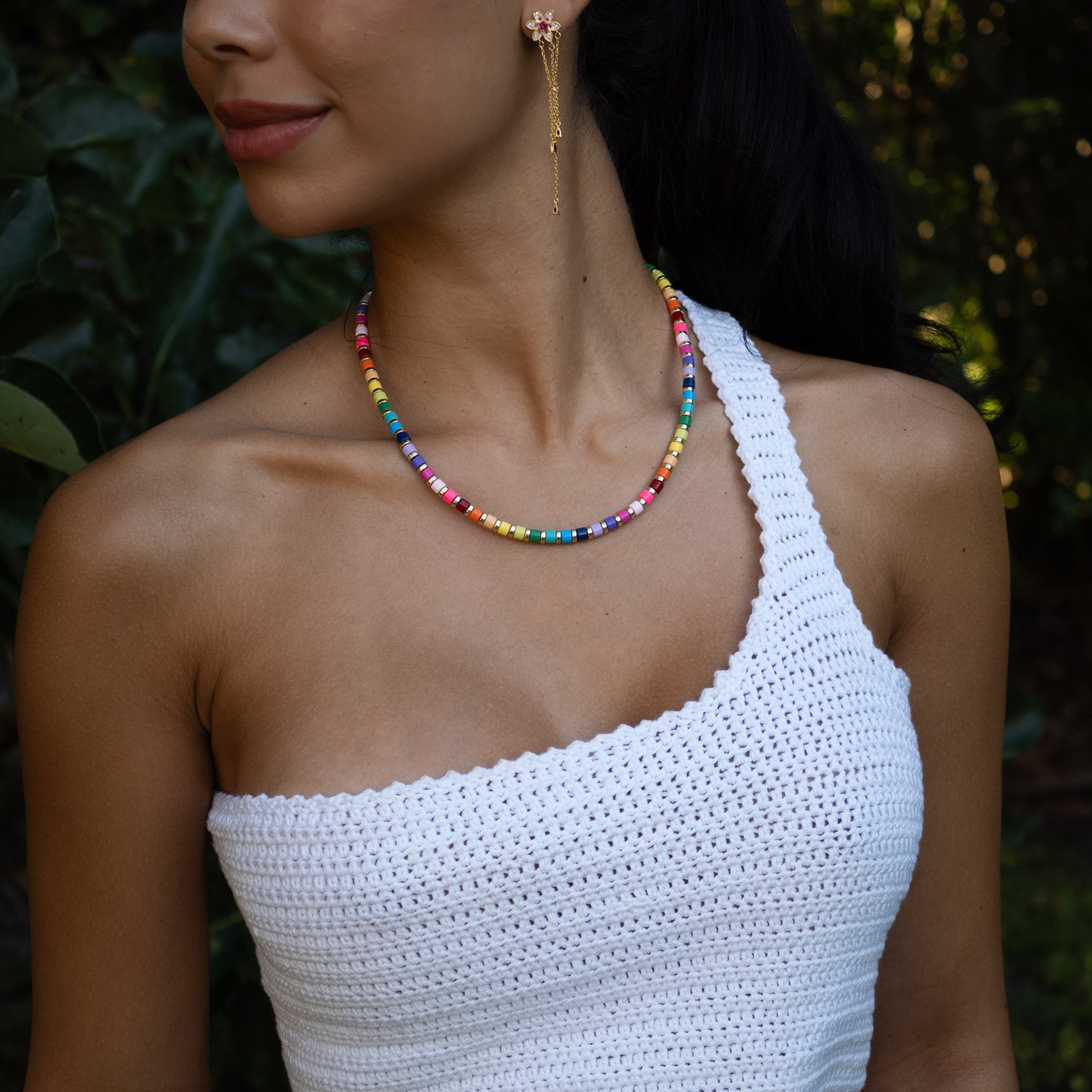 Close view of colorful rainbow choker necklace styled on white halter top