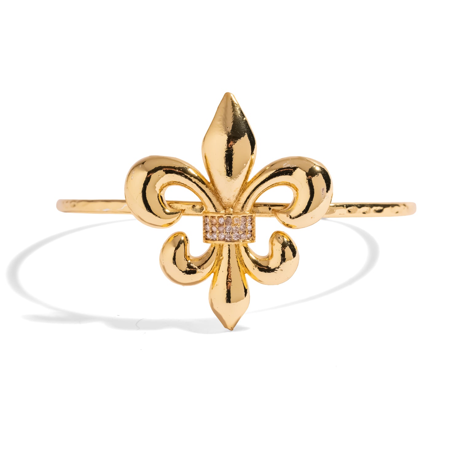 Close-up of the fleur de lis motif and pave crystal band on the gold cuff bracelet
