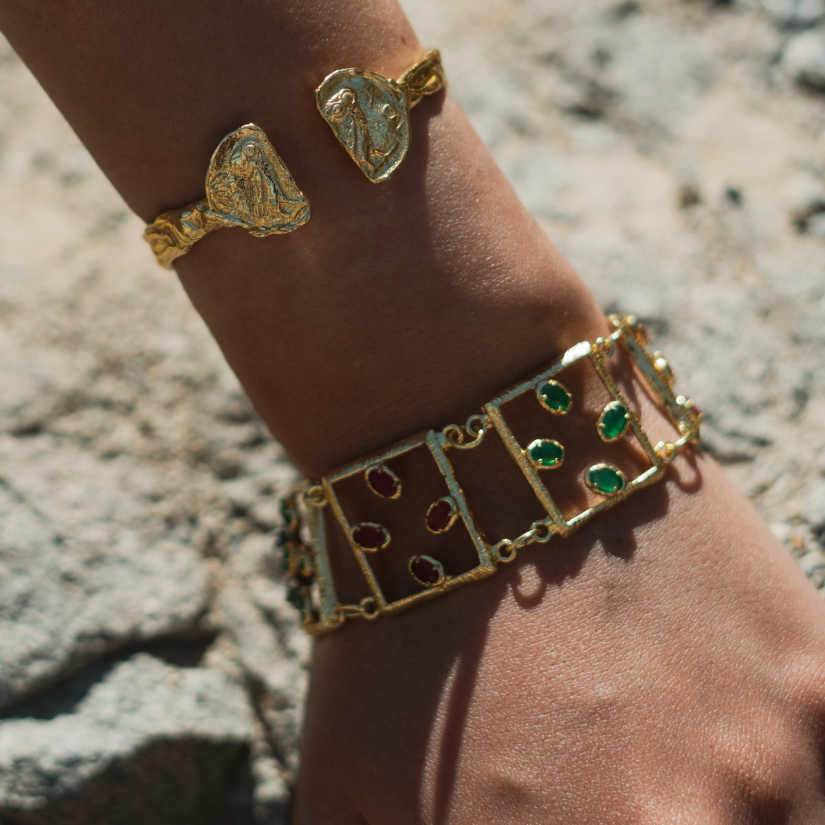 Ruby & Emerald Gemstone Open Square Gold Link Bracelet worn in sunlight, stacked with a gold owl coin cuff bracelet