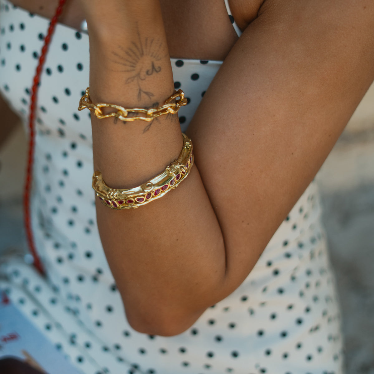 Ruby Teardrop Antique Anatolian Symbols Gold Cuff Bracelet worn on the wrist beside a gold link bracelet
