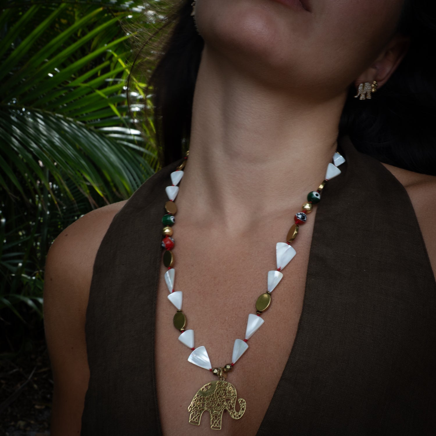 Model wearing Sacred Elephant Talisman beaded necklace with filigree pendant at chest, Ebru Jewelry