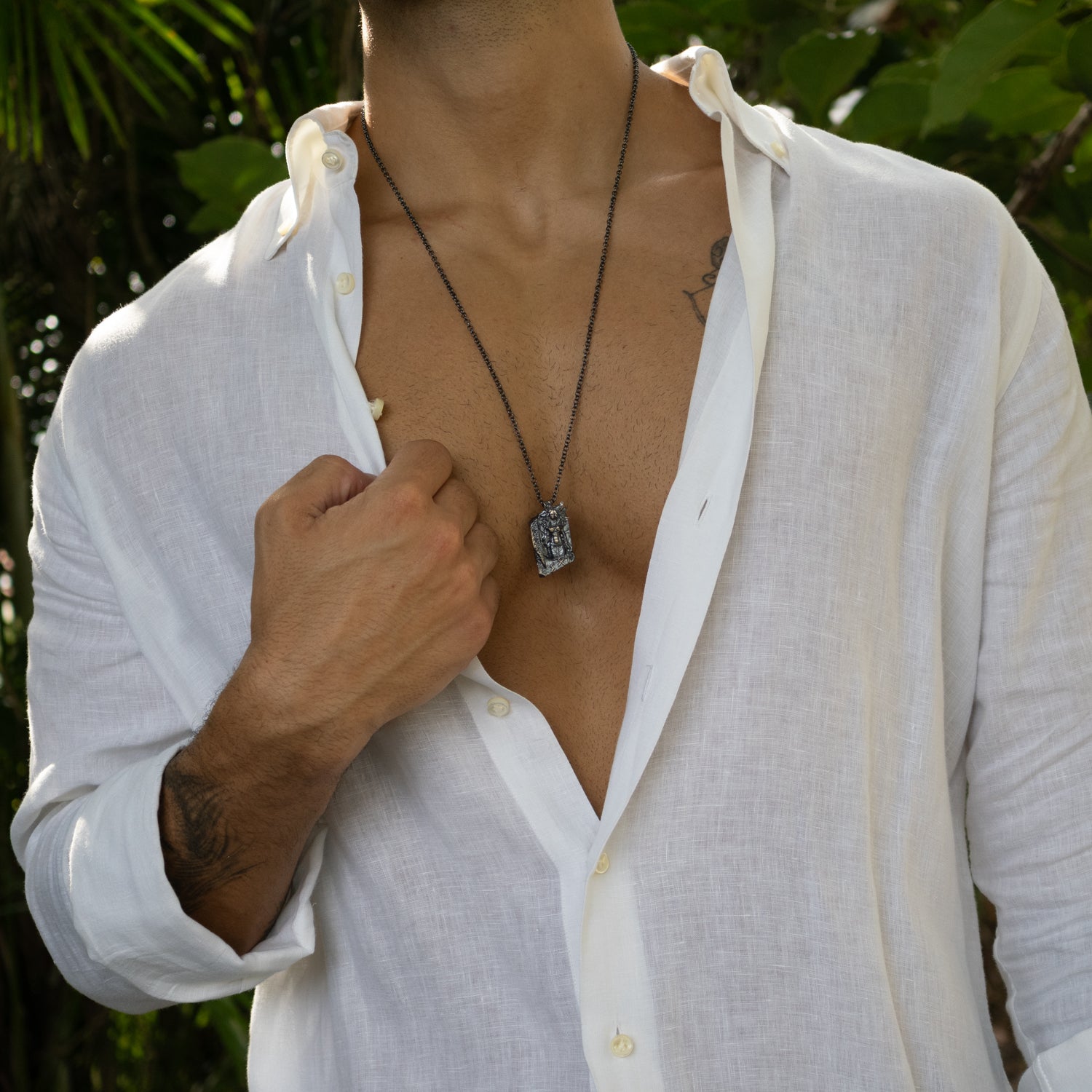 Sterling silver necklace with intricately detailed Santa Muerte pendant, dark rhodium finish, black accents, sturdy chain, bold gothic style.