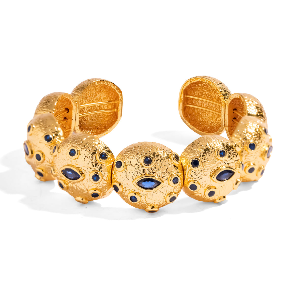 Sapphire Watchful Eye gold cuff bracelet of linked textured domes, each set with a marquise blue zircon eye and scattered round blue zircons