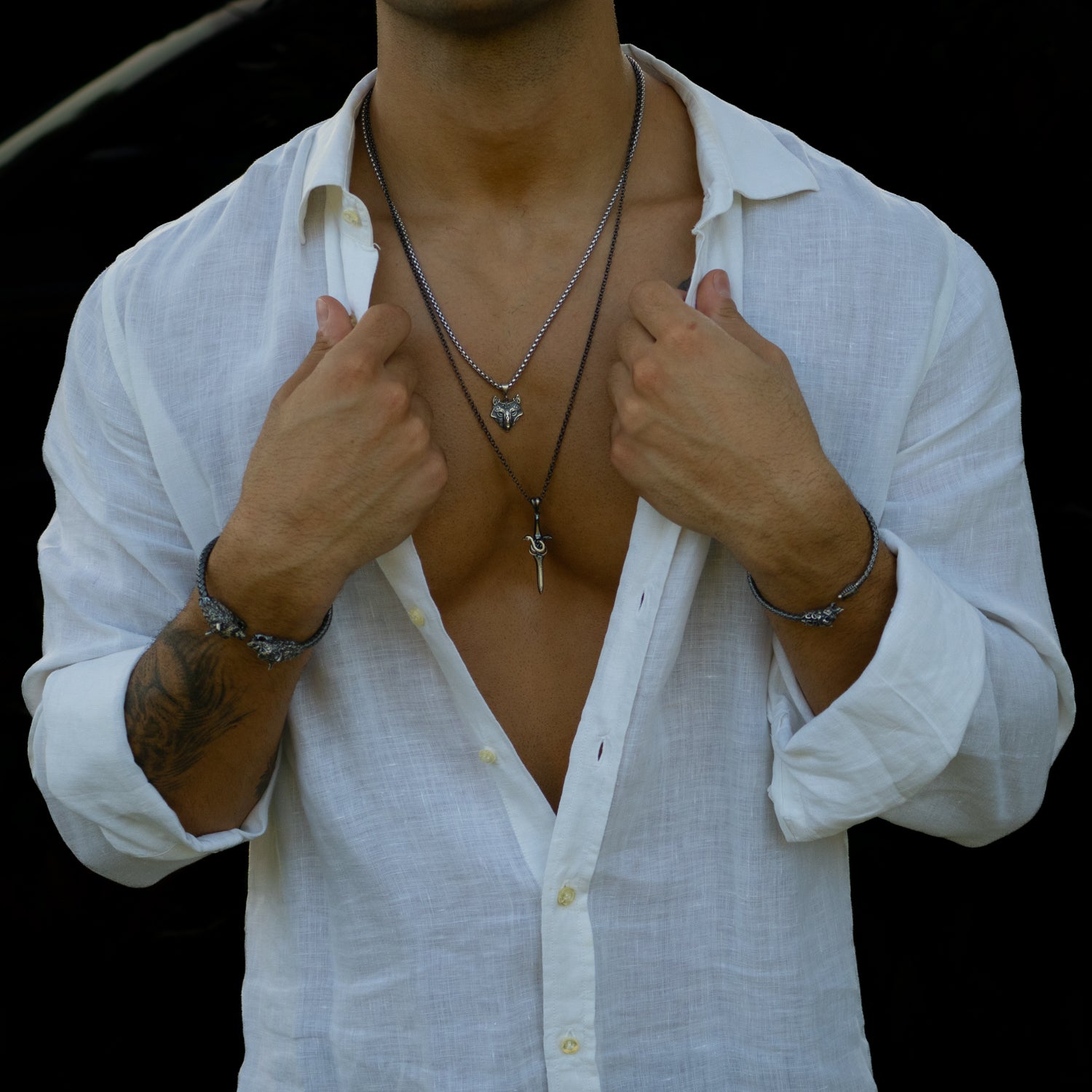 Sterling silver necklace with sword pendant entwined by a serpent, rhodium finish, black and silver accents, bold masculine style.