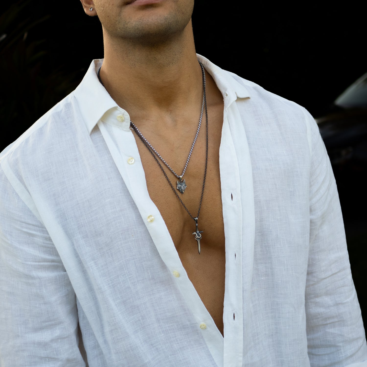 Sterling silver necklace with sword pendant entwined by a serpent, rhodium finish, black and silver details, bold masculine style.