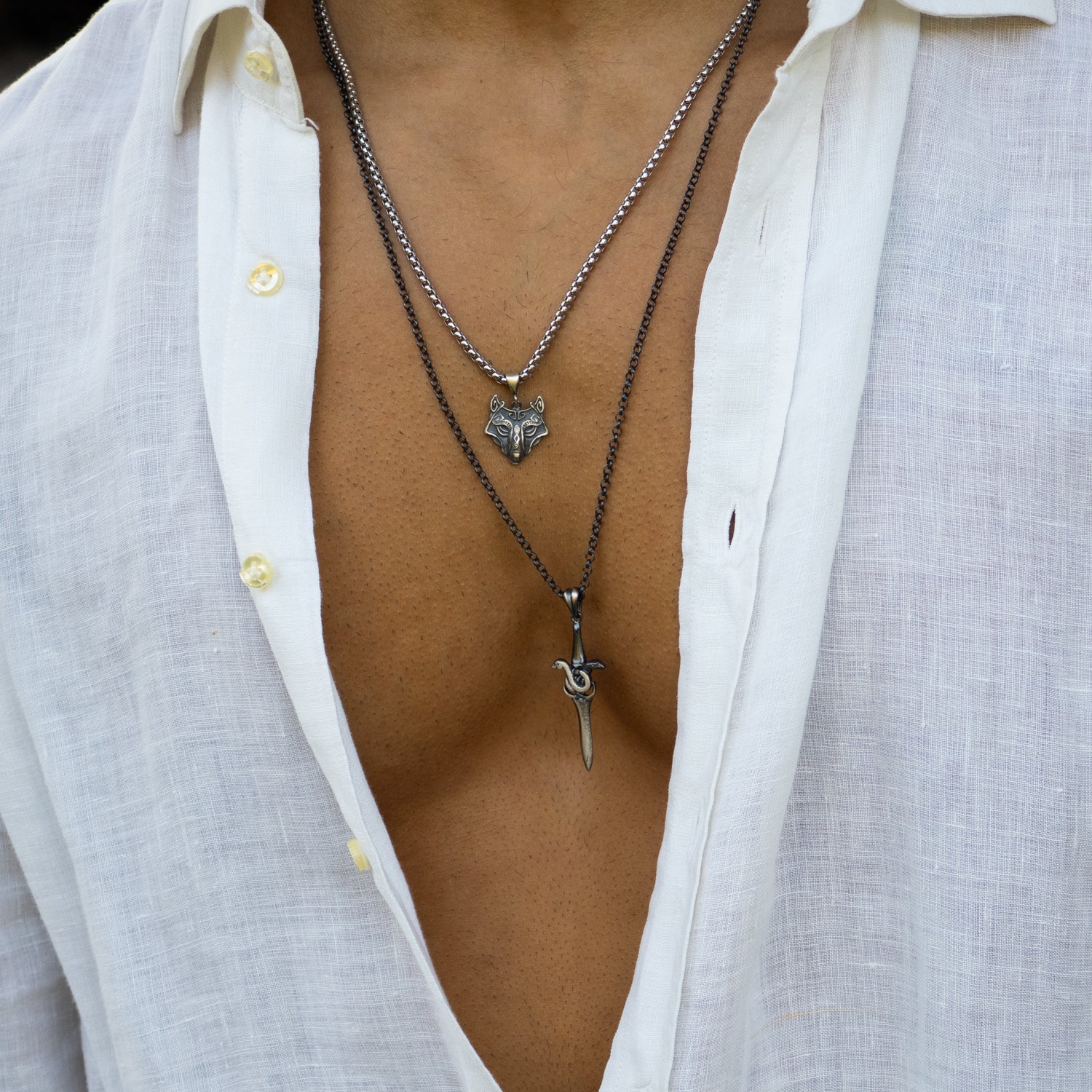 Sterling silver necklace with sword pendant entwined by a serpent, rhodium finish, black and silver details, bold masculine style.