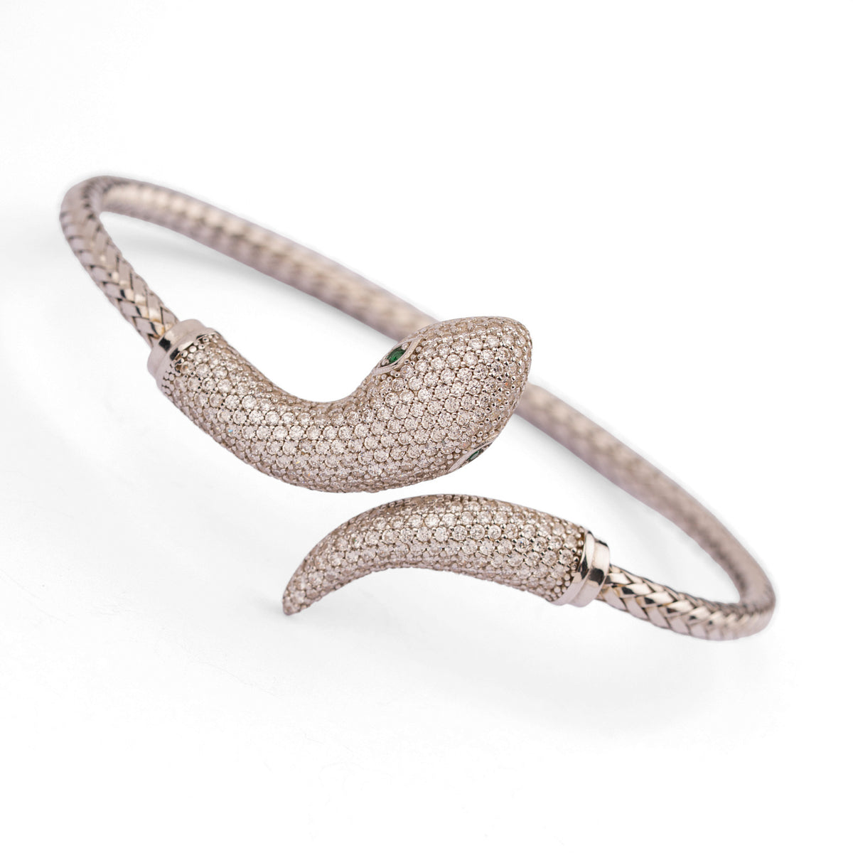 Angled view of the serpent cuff showing the emerald green zircon eye and the hand woven sterling silver band