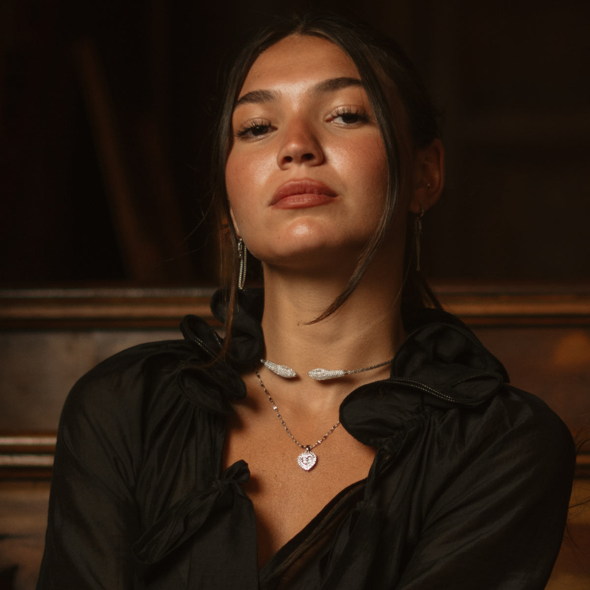 Portrait of a woman wearing the silver serpent choker with gold hoop earrings