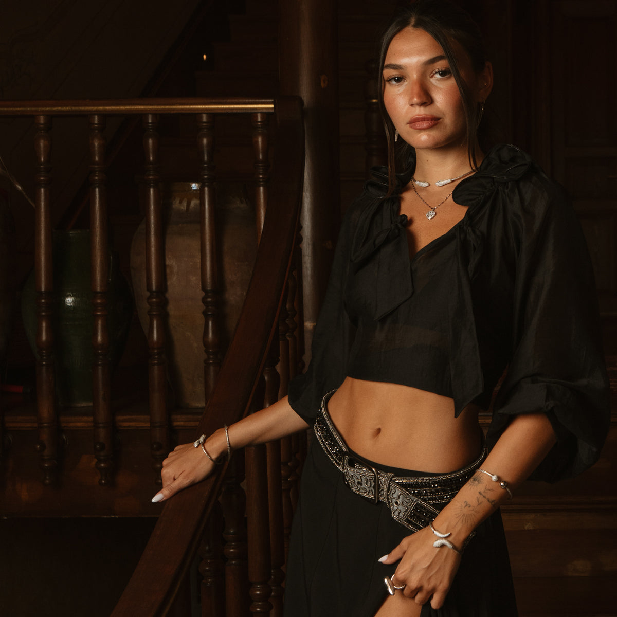 Woman in a black crop top wearing the woven silver serpent choker