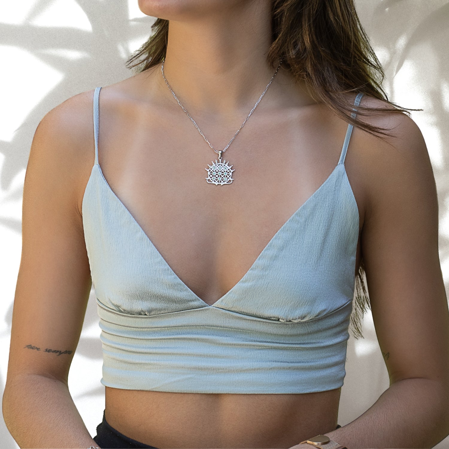 A model wearing the Silver Hittite Sun Disc Necklace, radiating with the positive energy and elegance of the jade or ruby stone.