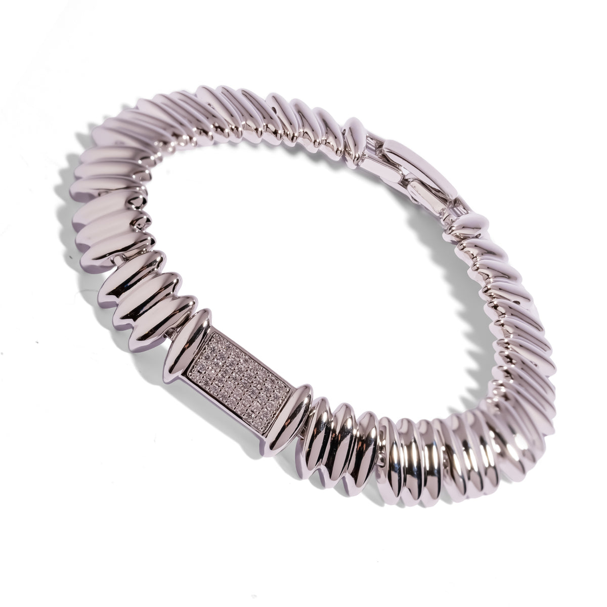 Silver Rhythm link bracelet at an angle, ribbed silver links curving toward the push-button box clasp