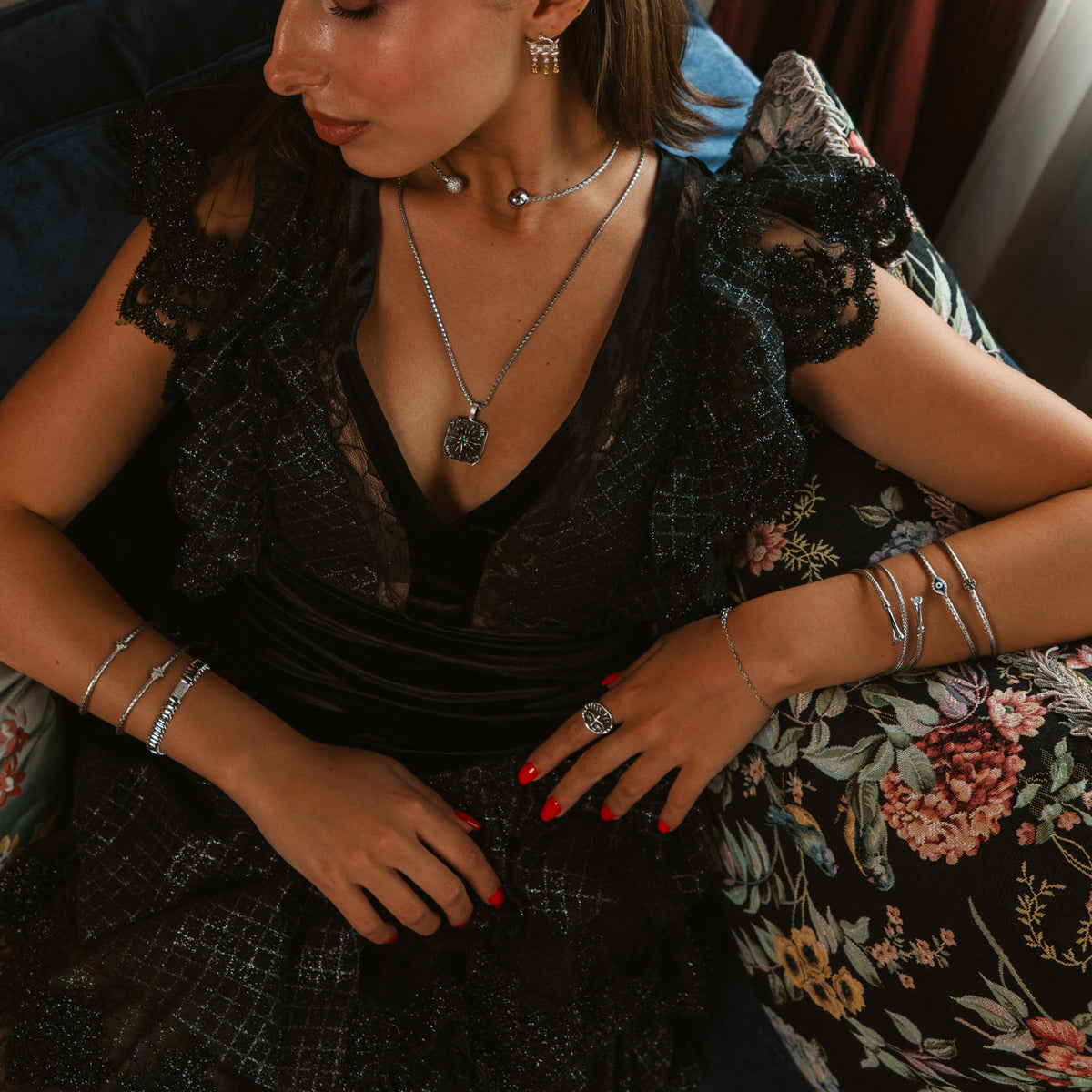 Model in a black lace dress with silver bracelets on both wrists, the Silver Rhythm link bracelet stacked at the left wrist