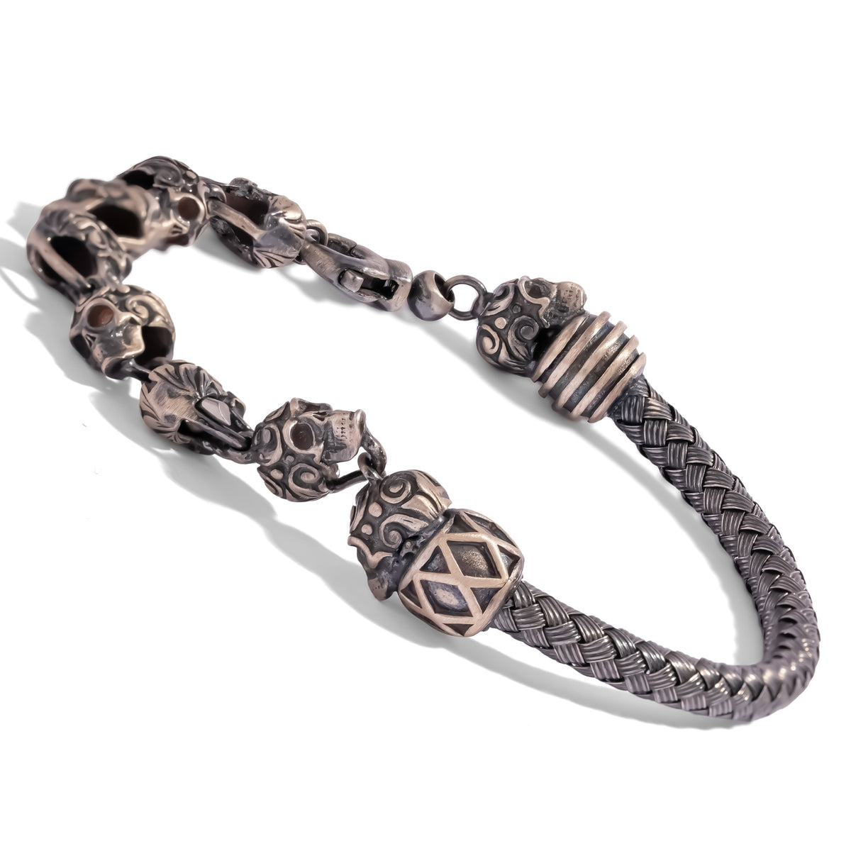 Angled view of the oxidized silver skull bracelet showing the lattice barrel bead, ribbed end cap and sculpted skull links