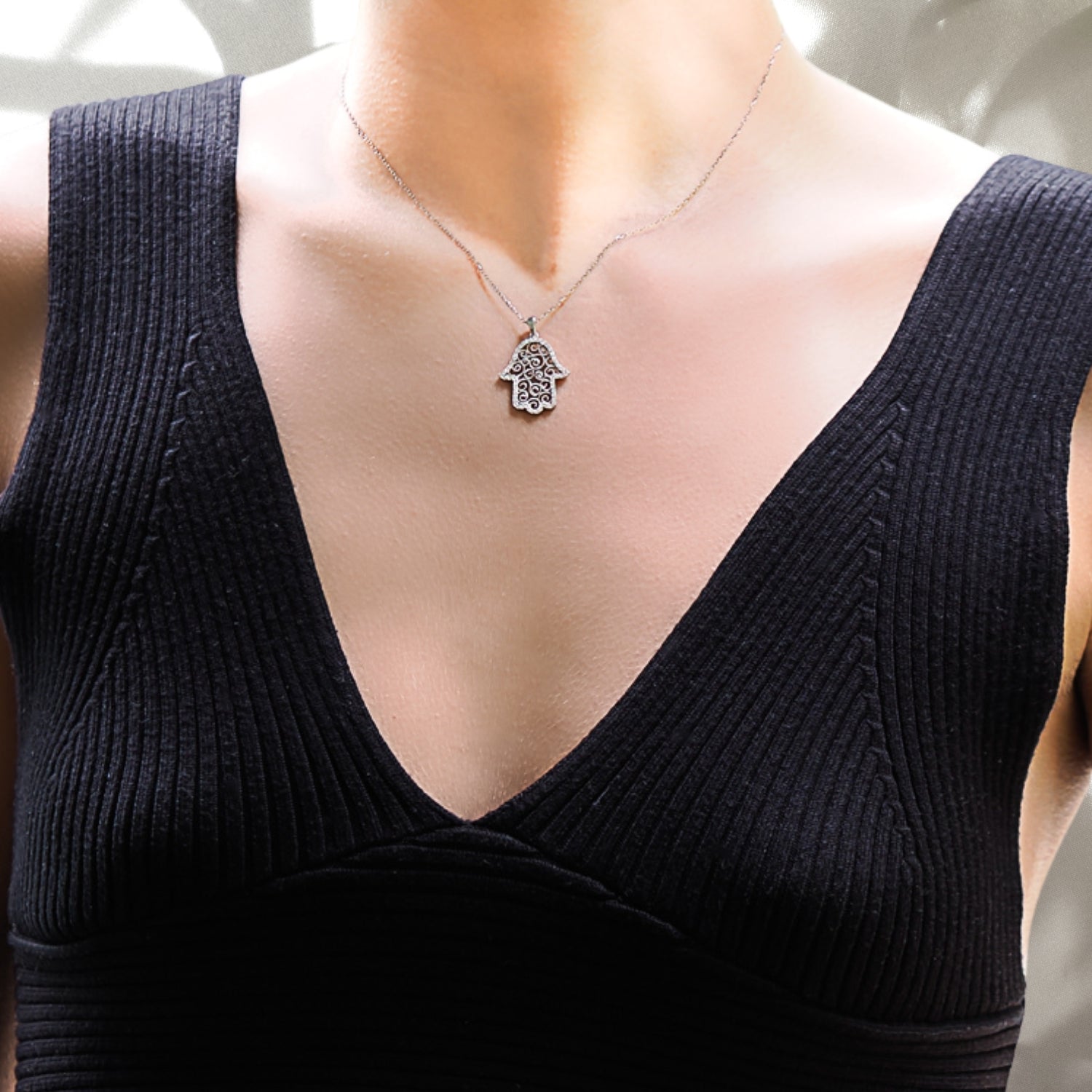 With grace and style, the model wears the Spiral Hamsa Necklace, highlighting the delicate Hamsa pendant adorned with sparkling CZ diamonds, representing blessings and good fortune.
