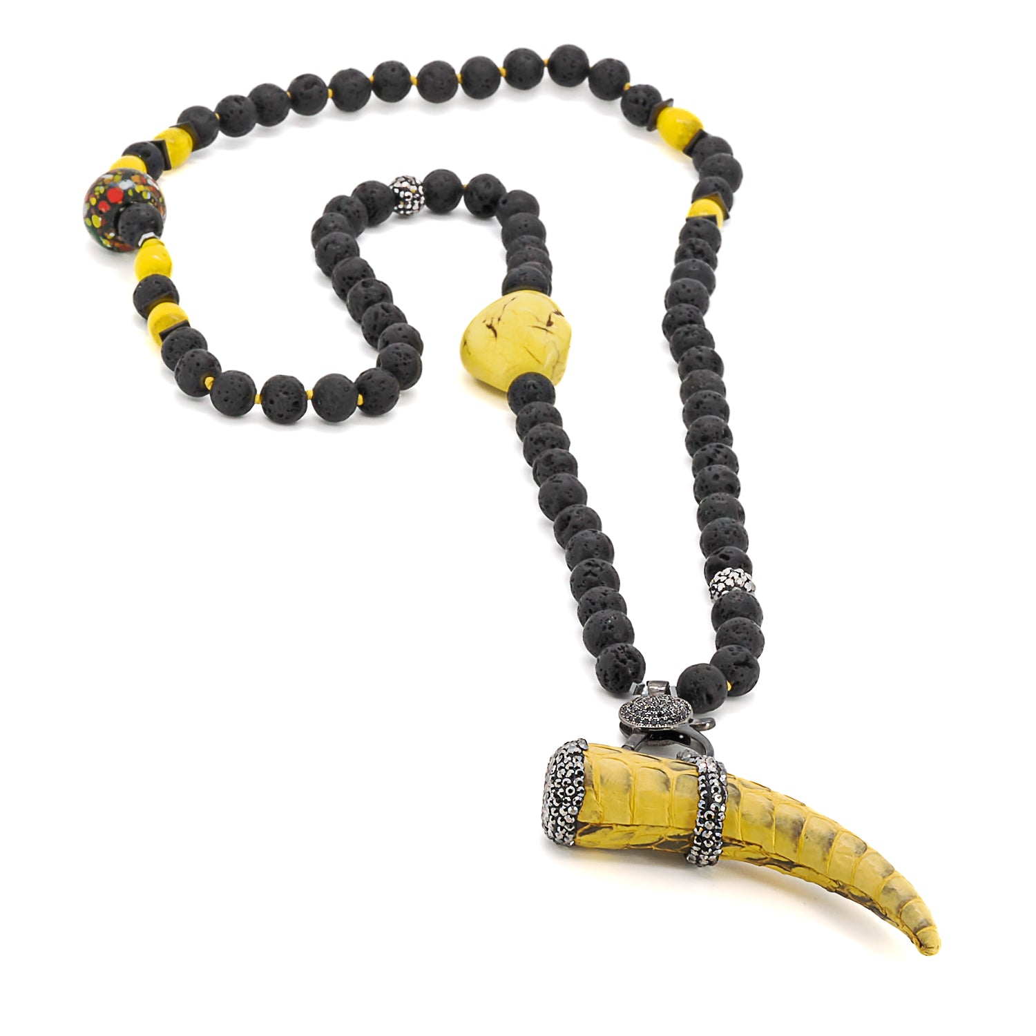 Close-up of the unique yellow and zircon Cornicello pendant, beautifully contrasting against the black lava rock stones in the Spirit Cornicello Unique Necklace.