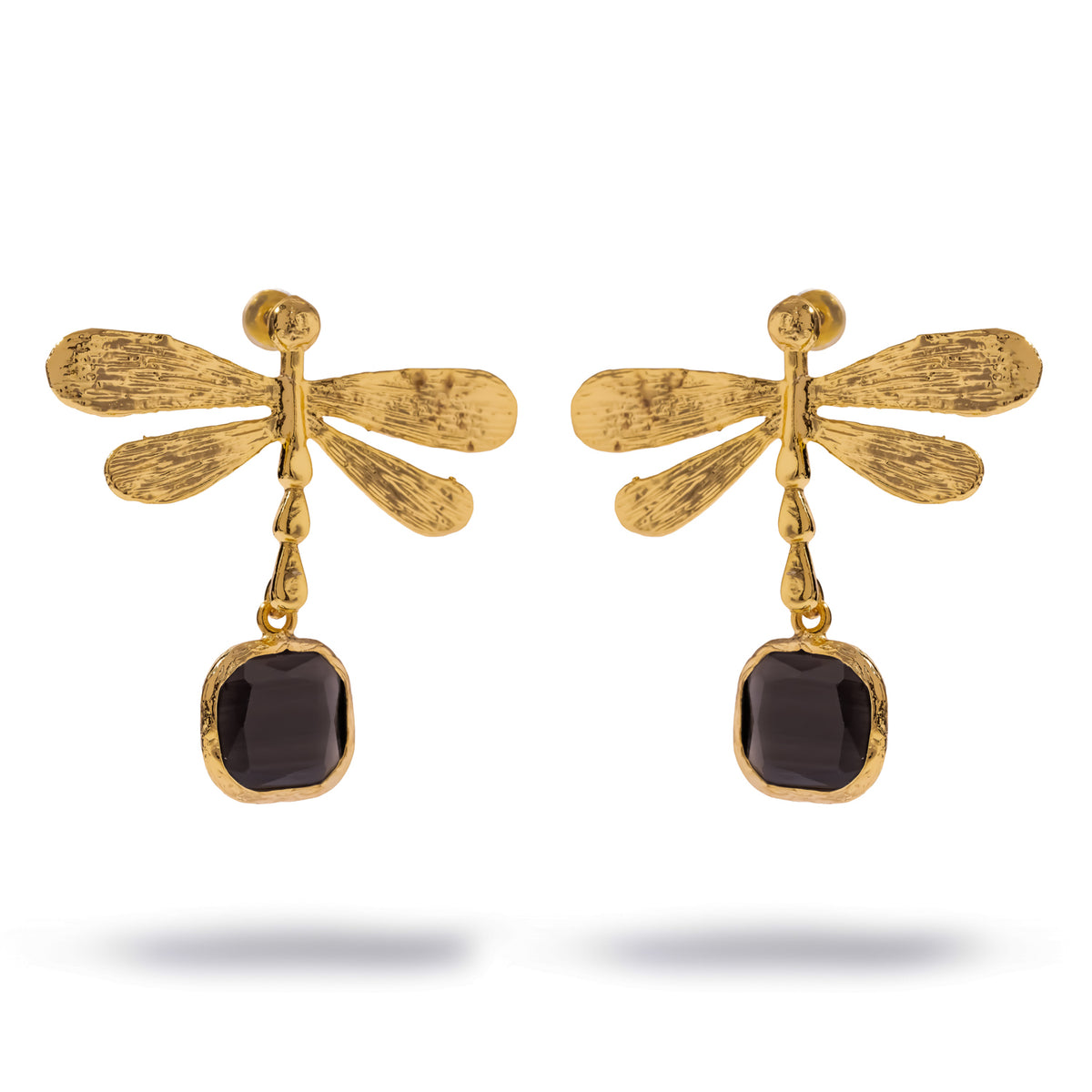 Pair of Spiritual Dragonfly gold drop earrings on white, veined gold wings above a cushion cut black cat's eye stone