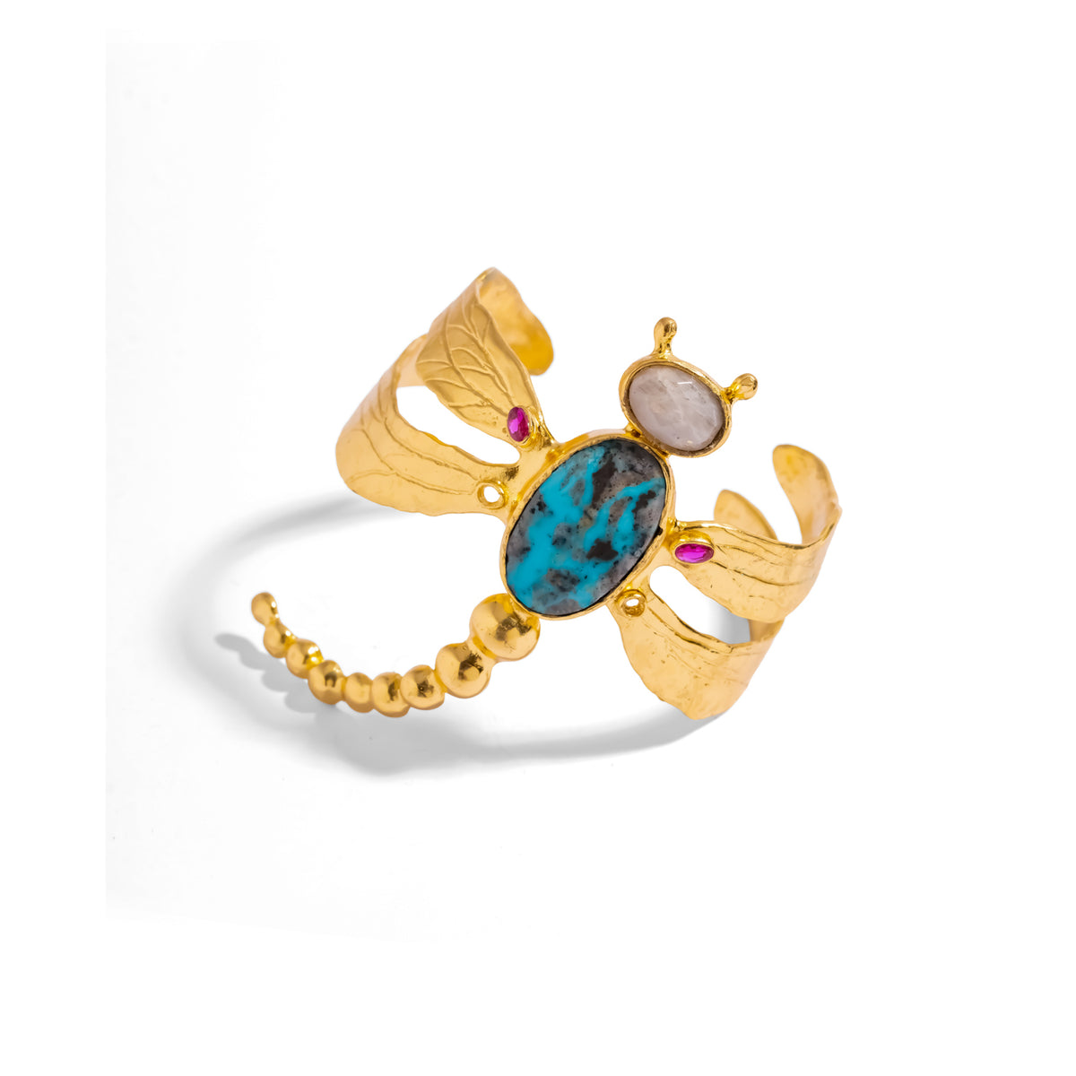 Gold dragonfly cuff bracelet with turquoise body and ruby wing accents, shown at a distance on white