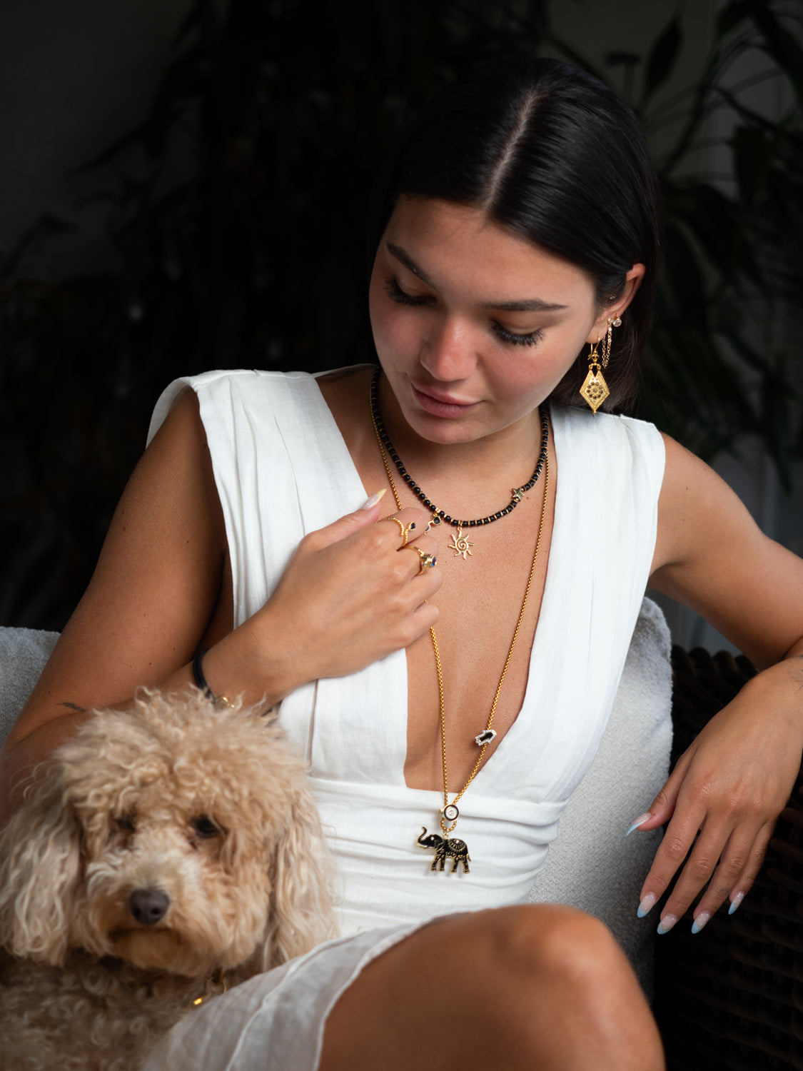 Model wearing spiritual elephant talisman necklace layered with black onyx beaded sun necklace