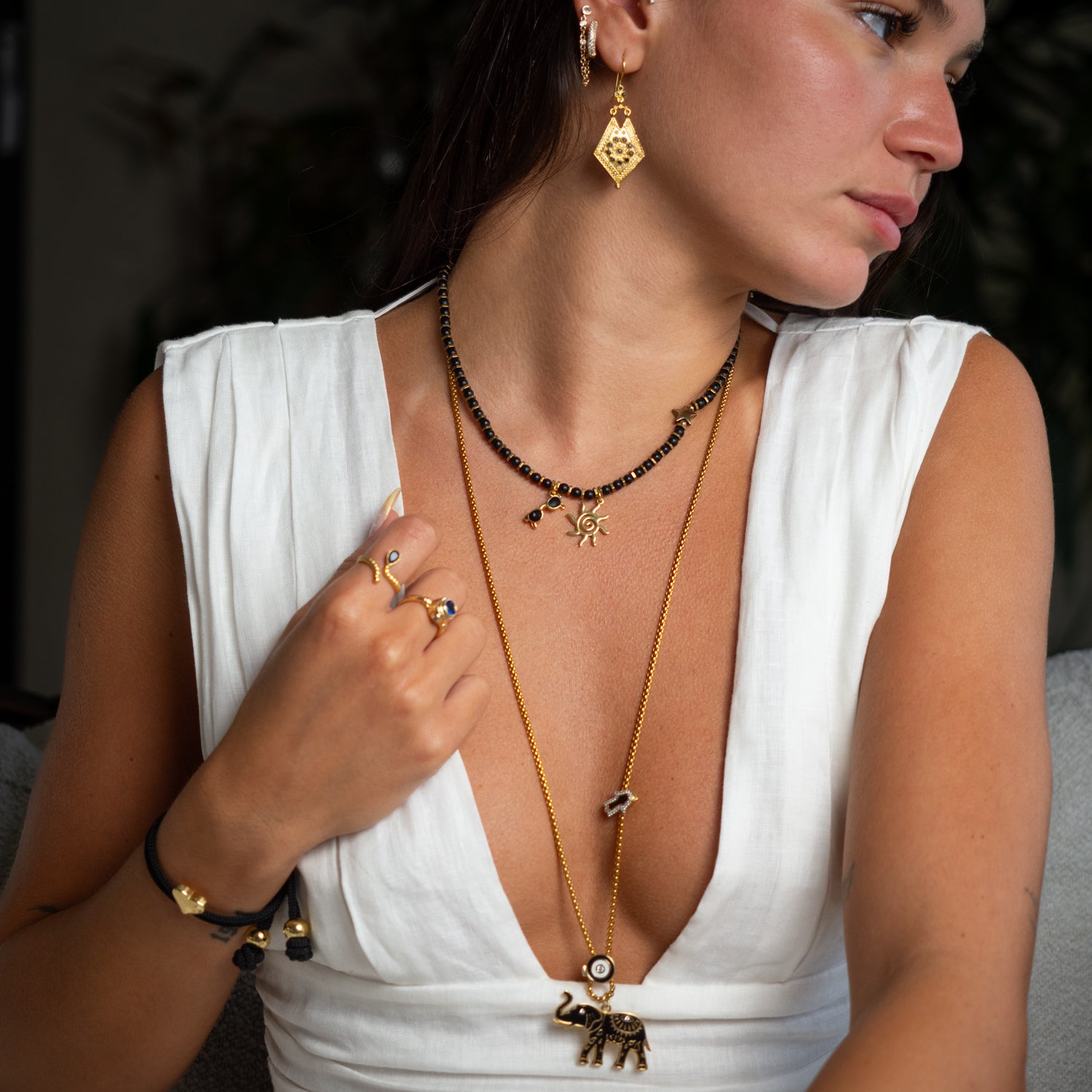 Layered necklace look featuring long elephant talisman chain and black onyx choker, summer styling