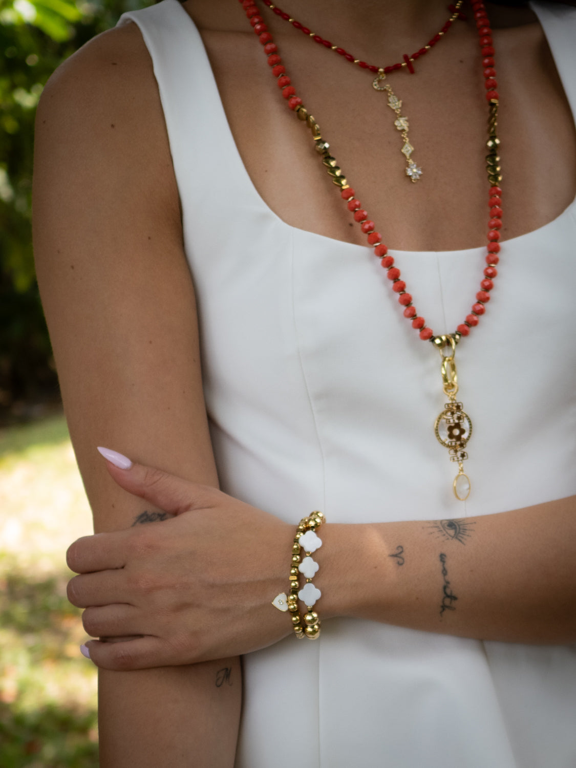 Close-up of white enamel heart charm and gold-plated Swarovski crystal bead

