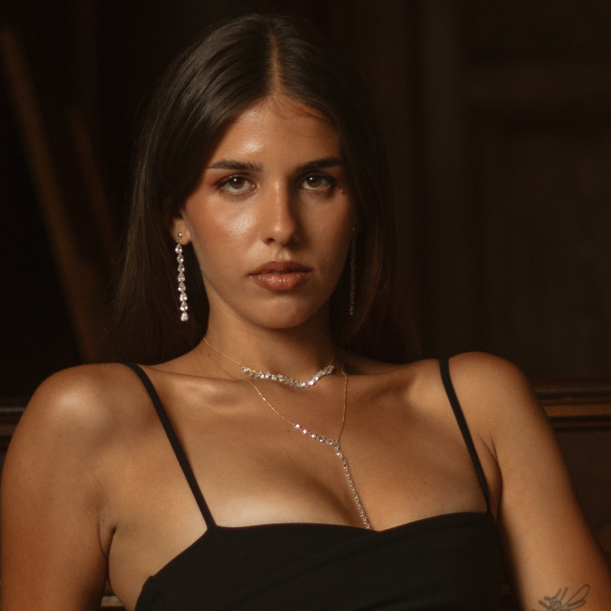 Model in a black top wearing the Starlight Glow zircon choker layered with a Y drop necklace