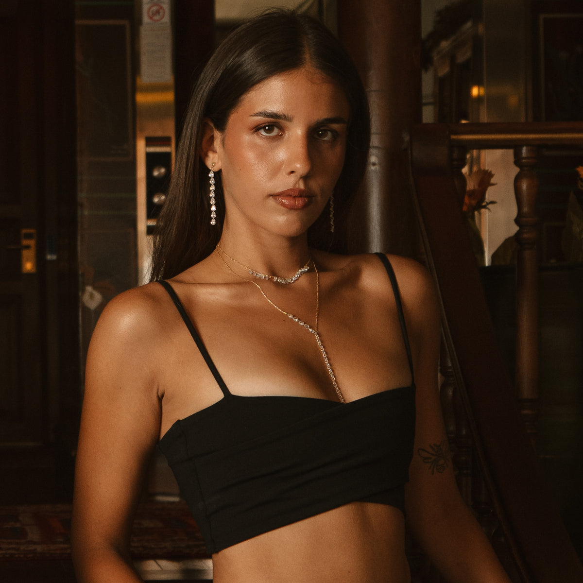 Model in a black top wearing the Starlight Pear Zircon Y Drop Gold Necklace with long zircon earrings